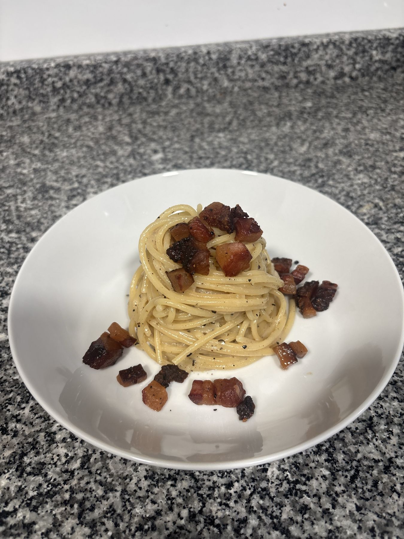 Pasta gricia twirled high and topped with crisp guanciale