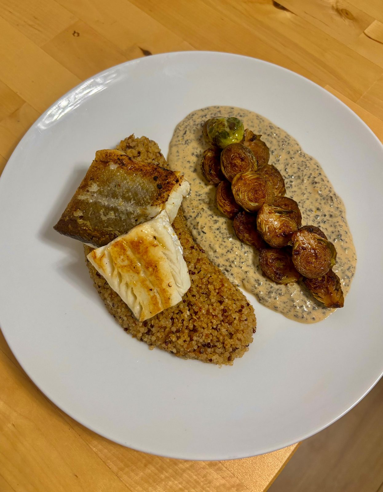 Lime cod with quinoa and Brussels sprouts over a creamy sauce